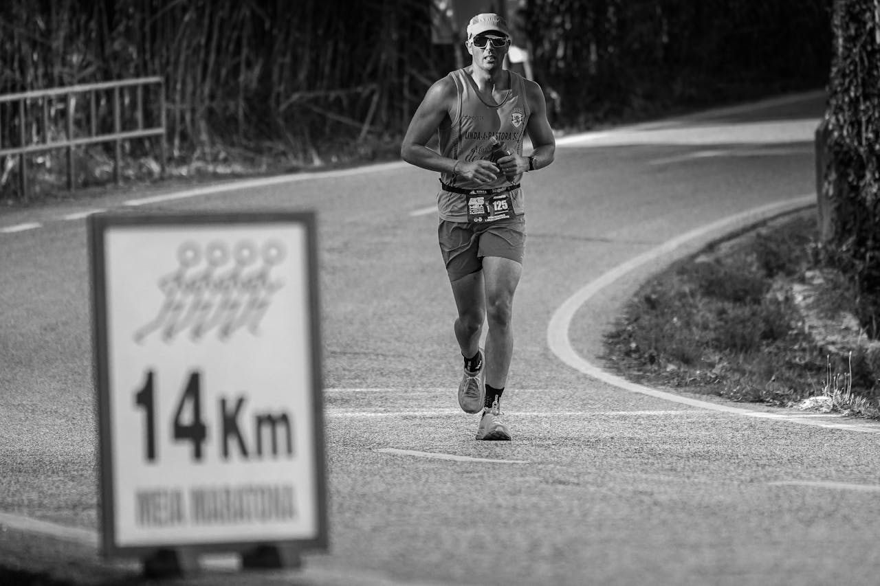 A determined runner participating in a marathon at the 14Km mark on outdoor city streets.